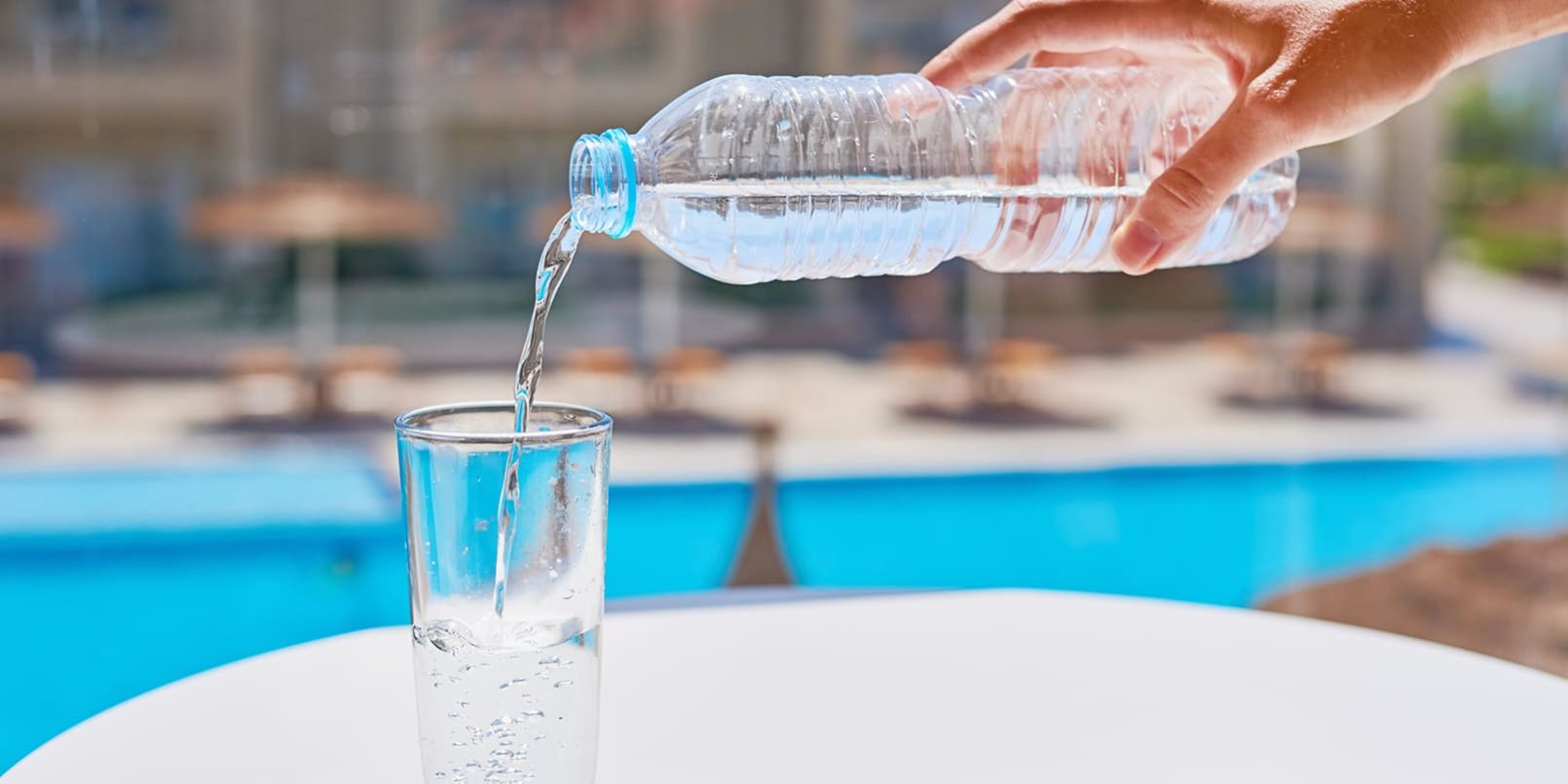 woman-hand-pouring-water-in-a-glass-from-bottle